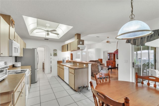 22946 Brownwood Ct, Land O Lakes, FL 34639 - kitchen with ceiling fan, white appliances, a raised ceiling, light tile patterned floors, and open floor plan