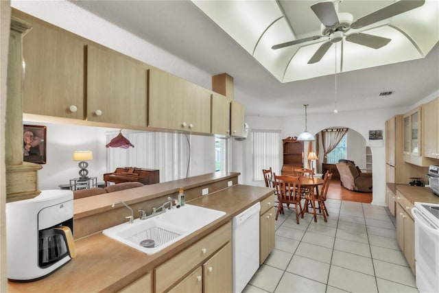 22946 Brownwood Ct, Land O Lakes, FL 34639 - kitchen with white appliances, light tile patterned floors, arched walkways, light brown cabinets, and open floor plan
