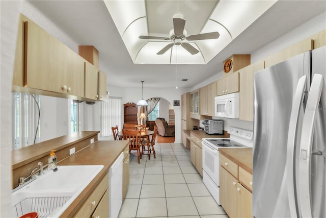 22946 Brownwood Ct, Land O Lakes, FL 34639 - kitchen featuring white appliances, light tile patterned floors, ceiling fan, light brown cabinetry, and decorative light fixtures