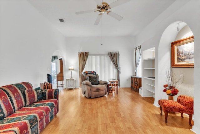 22946 Brownwood Ct, Land O Lakes, FL 34639 - living area with arched walkways, light wood-style floors, and a ceiling fan
