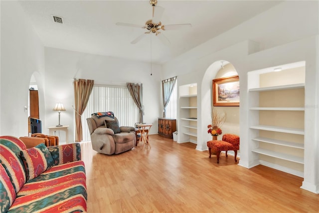 22946 Brownwood Ct, Land O Lakes, FL 34639 - living area featuring built in features, light wood-style flooring, arched walkways, and a ceiling fan