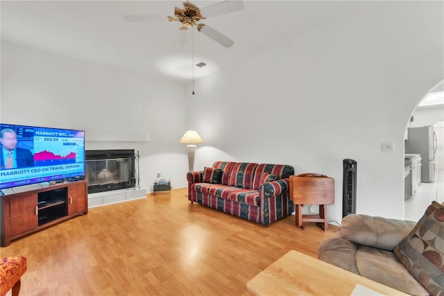 22946 Brownwood Ct, Land O Lakes, FL 34639 - living area with ceiling fan, arched walkways, wood finished floors, and a fireplace