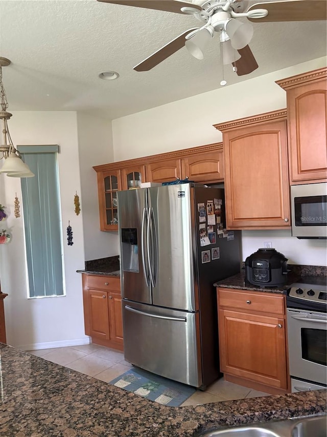 1855 Briland St, Tarpon Springs, FL 34689 - kitchen featuring stainless steel appliances, ceiling fan, glass insert cabinets, dark stone counters, and light tile patterned flooring
