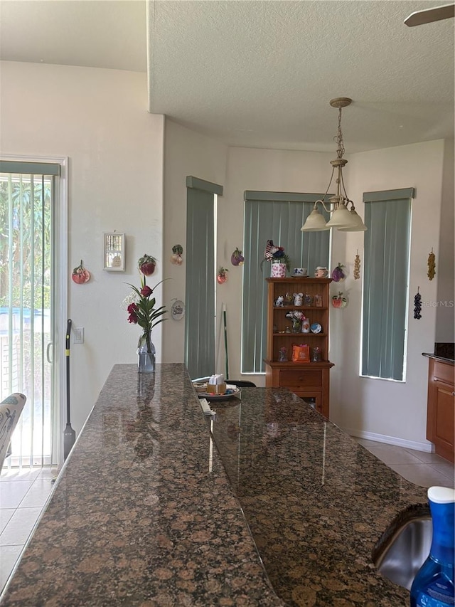 1855 Briland St, Tarpon Springs, FL 34689 - kitchen with light tile patterned floors, a textured ceiling, and decorative light fixtures