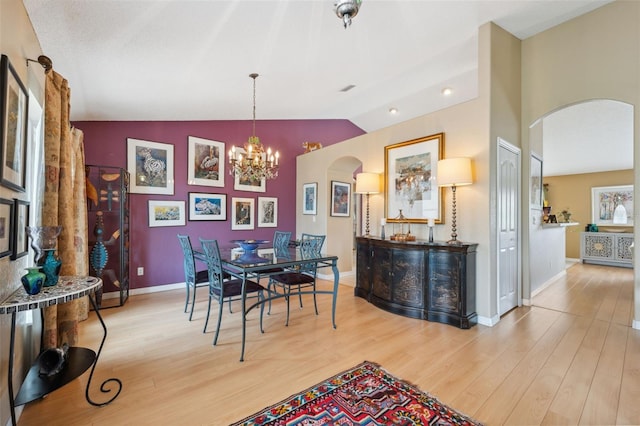 13238 Asbury St, Spring Hill, FL 34609 - dining area featuring arched walkways, vaulted ceiling, a chandelier, wood finished floors, and baseboards