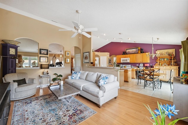 13238 Asbury St, Spring Hill, FL 34609 - living area featuring arched walkways, ceiling fan, light wood-style flooring, and high vaulted ceiling