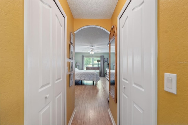 13238 Asbury St, Spring Hill, FL 34609 - corridor featuring a textured ceiling, a textured wall, and wood finished floors