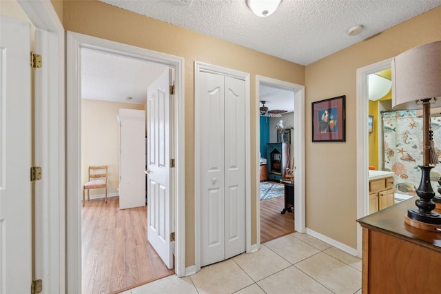 13238 Asbury St, Spring Hill, FL 34609 - hall with a textured ceiling, baseboards, and light tile patterned flooring