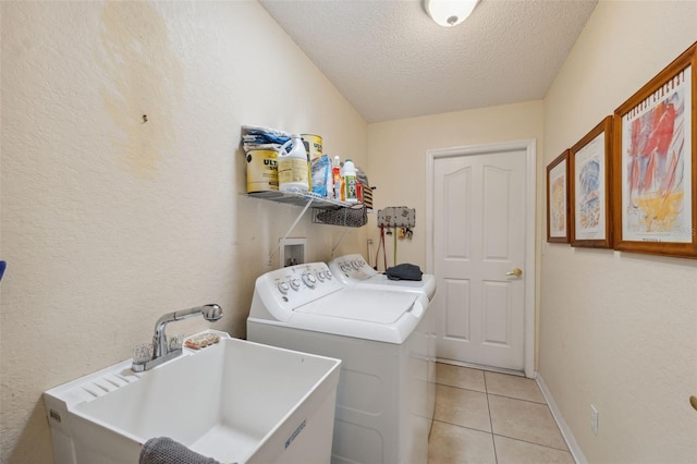 13238 Asbury St, Spring Hill, FL 34609 - laundry area with washer and dryer, a textured ceiling, light tile patterned floors, baseboards, and a textured wall