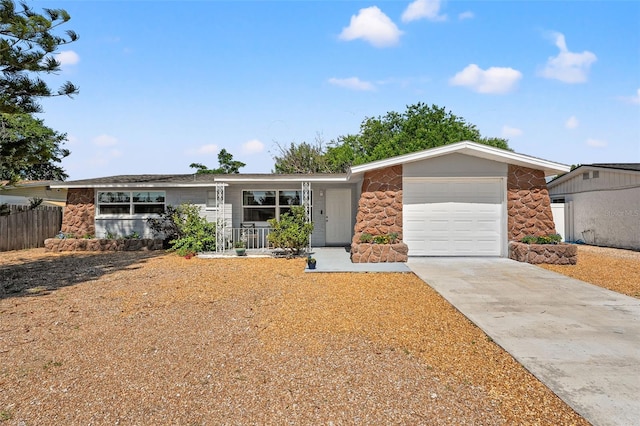 4922 Bola St, New Port Richey, FL 34652 - view of front of house with stone siding, a garage, concrete driveway, and covered porch
