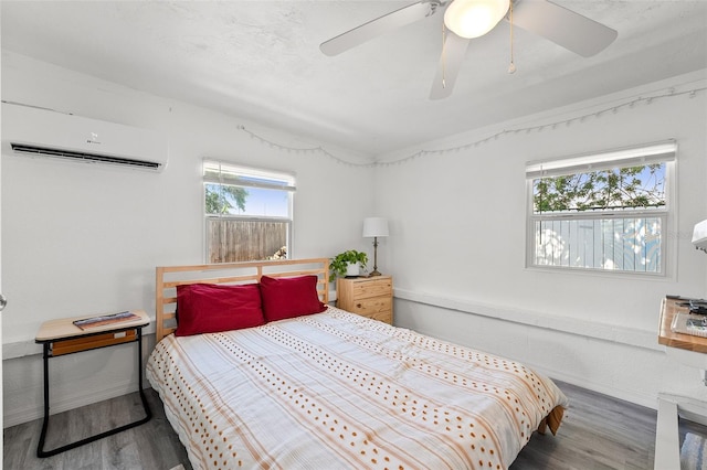 4922 Bola St, New Port Richey, FL 34652 - bedroom with a wall mounted air conditioner, multiple windows, wood finished floors, and a ceiling fan