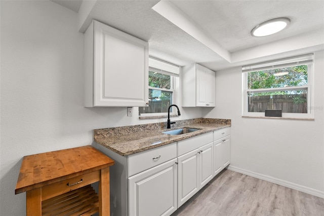 4922 Bola St, New Port Richey, FL 34652 - kitchen featuring light wood-type flooring, white cabinets, and light stone countertops