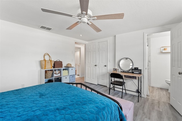 4922 Bola St, New Port Richey, FL 34652 - bedroom with wood finished floors, a textured ceiling, a ceiling fan, and connected bathroom