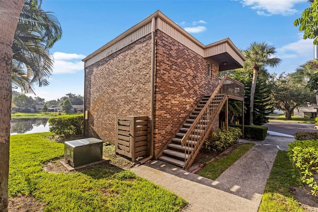 10423 Carrollbrook Cir Unit 203, Tampa, FL 33618 - view of side of home with brick siding, a water view, and stairway