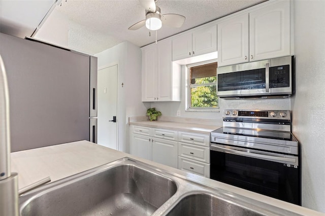 10423 Carrollbrook Cir Unit 203, Tampa, FL 33618 - kitchen featuring appliances with stainless steel finishes, white cabinets, a textured ceiling, light countertops, and ceiling fan