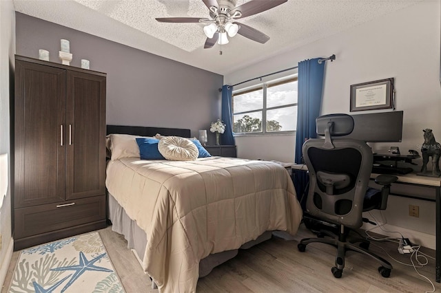 10423 Carrollbrook Cir Unit 203, Tampa, FL 33618 - bedroom with a textured ceiling, light wood-type flooring, a ceiling fan, and an office area