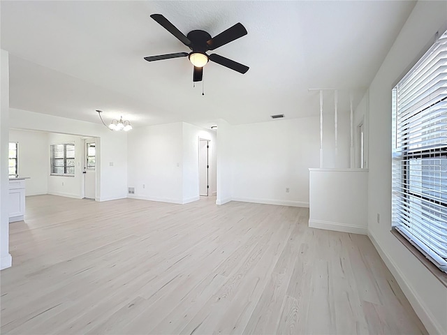 21426 Quesada Ave, Port Charlotte, FL 33952 - unfurnished living room with ceiling fan, light wood-style floors, and a chandelier