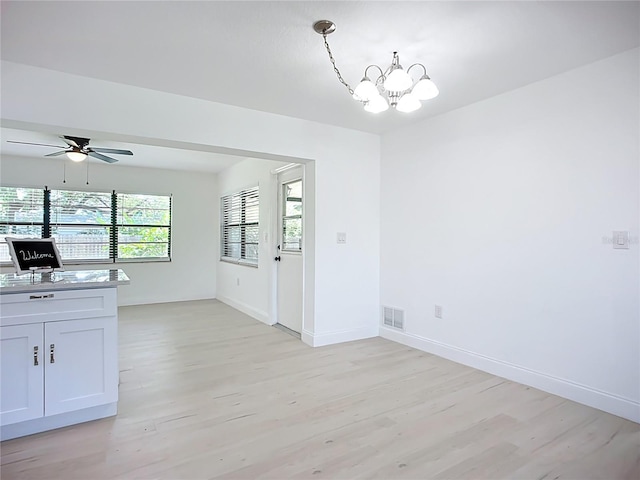 21426 Quesada Ave, Port Charlotte, FL 33952 - unfurnished dining area featuring light wood-style flooring, a chandelier, and a ceiling fan
