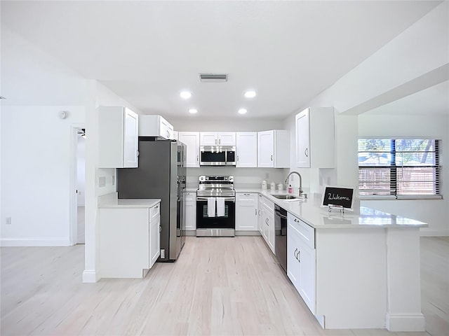 21426 Quesada Ave, Port Charlotte, FL 33952 - kitchen with appliances with stainless steel finishes, light wood-style flooring, white cabinetry, light countertops, and recessed lighting