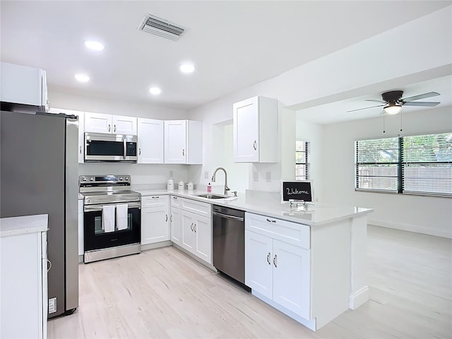 21426 Quesada Ave, Port Charlotte, FL 33952 - kitchen featuring stainless steel appliances, light wood-type flooring, ceiling fan, white cabinetry, and light countertops