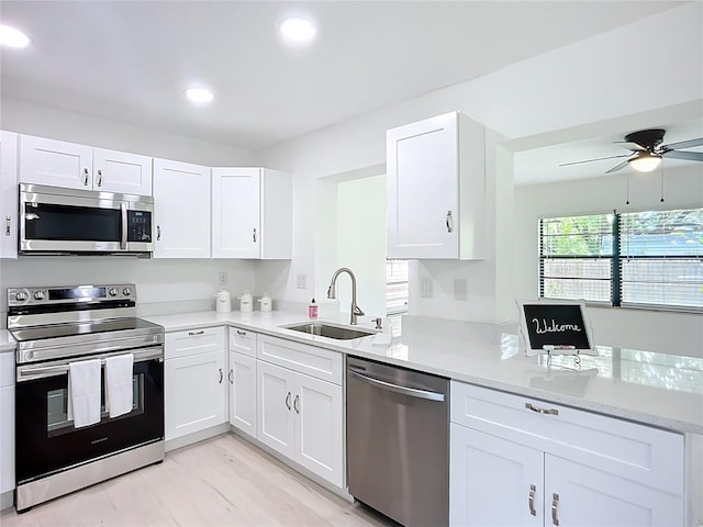 21426 Quesada Ave, Port Charlotte, FL 33952 - kitchen featuring stainless steel appliances, a ceiling fan, white cabinets, recessed lighting, and a peninsula