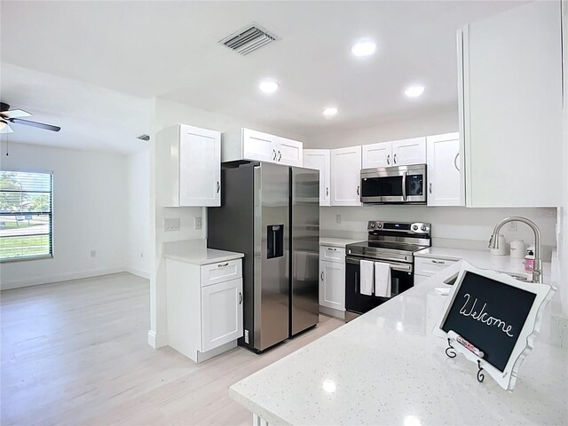 21426 Quesada Ave, Port Charlotte, FL 33952 - kitchen with appliances with stainless steel finishes, ceiling fan, light stone counters, white cabinets, and recessed lighting