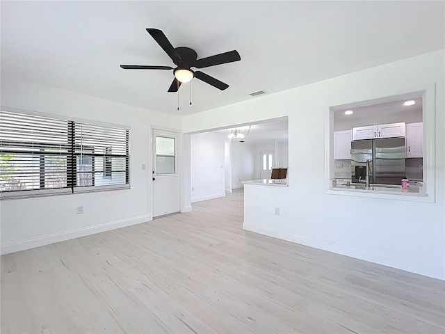 21426 Quesada Ave, Port Charlotte, FL 33952 - unfurnished living room featuring a ceiling fan, light wood-style flooring, and a chandelier