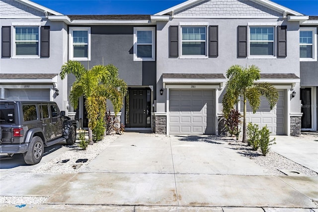 2801 Midnight Pearl Dr, Sarasota, FL 34240 - multi unit property with stucco siding, a garage, concrete driveway, and stone siding