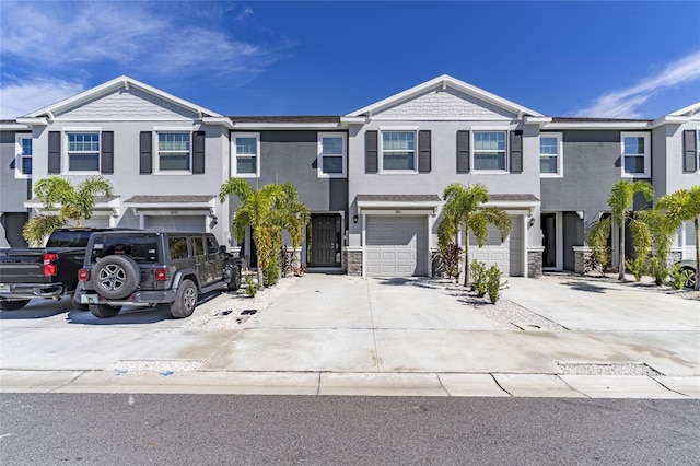 2801 Midnight Pearl Dr, Sarasota, FL 34240 - townhome / multi-family property featuring driveway, an attached garage, stucco siding, and stone siding