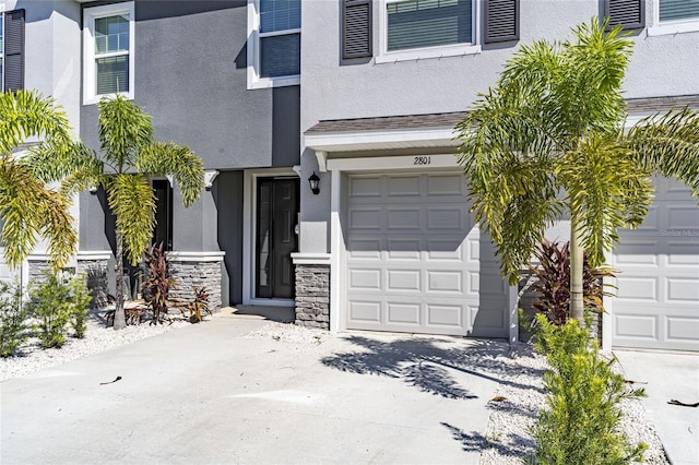 2801 Midnight Pearl Dr, Sarasota, FL 34240 - entrance to property with stucco siding, concrete driveway, an attached garage, and stone siding