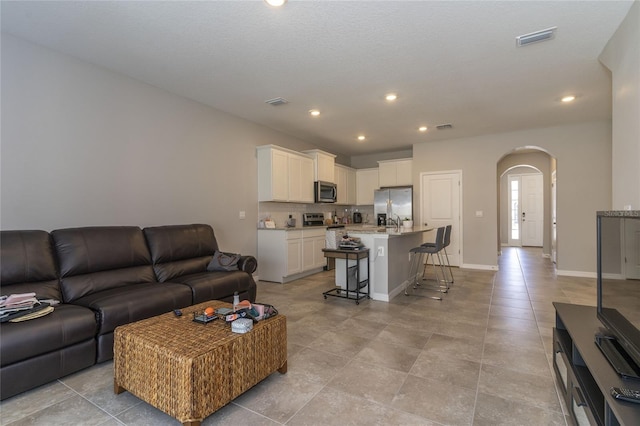 2801 Midnight Pearl Dr, Sarasota, FL 34240 - living room featuring arched walkways, recessed lighting, and baseboards