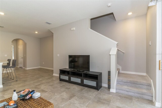 2801 Midnight Pearl Dr, Sarasota, FL 34240 - unfurnished living room featuring stairway, arched walkways, baseboards, recessed lighting, and light tile patterned floors