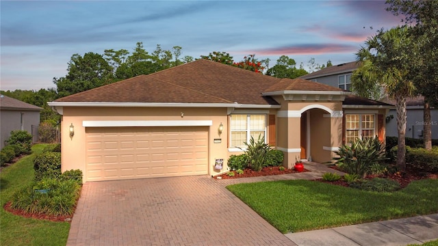 19418 Butterwood Ln, Lutz, FL 33558 - view of front of property with a garage, decorative driveway, stucco siding, and a lawn