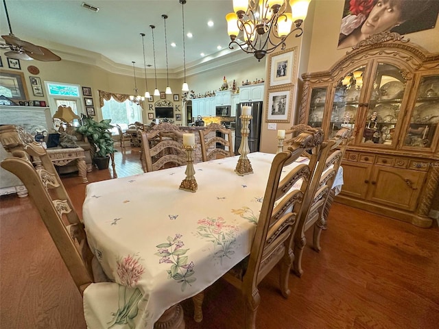 13807 Eagles Rock Ct, Hudson, FL 34667 - dining room featuring a chandelier, wood finished floors, ceiling fan, and ornamental molding