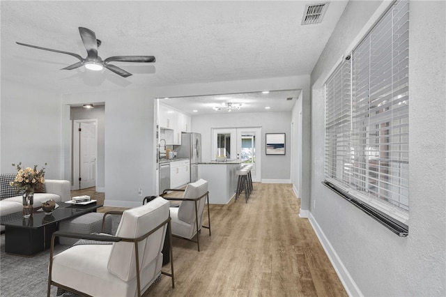 223 Pinehurst Dr, Auburndale, FL 33823 - living area with light wood-style floors, ceiling fan, and a textured ceiling