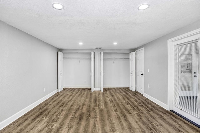 223 Pinehurst Dr, Auburndale, FL 33823 - unfurnished bedroom featuring multiple closets, wood finished floors, recessed lighting, and a textured ceiling