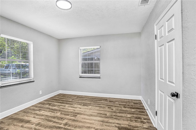 223 Pinehurst Dr, Auburndale, FL 33823 - spare room featuring plenty of natural light, dark wood finished floors, and a textured ceiling