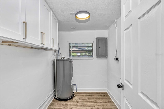 223 Pinehurst Dr, Auburndale, FL 33823 - laundry area featuring cabinet space, water heater, electric panel, a textured ceiling, and wood finished floors