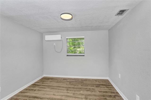 223 Pinehurst Dr, Auburndale, FL 33823 - unfurnished room with an AC wall unit, wood finished floors, and a textured ceiling