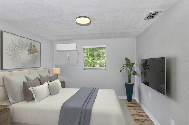 223 Pinehurst Dr, Auburndale, FL 33823 - bedroom featuring a wall mounted air conditioner, wood finished floors, and a textured ceiling
