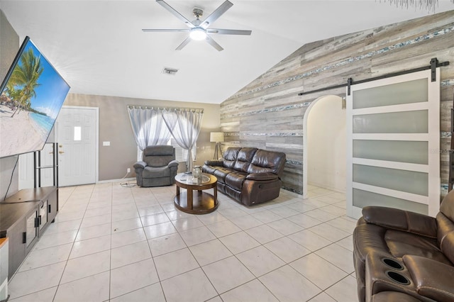 9642 Elgin Blvd, Spring Hill, FL 34606 - tiled living area featuring an accent wall, a barn door, vaulted ceiling, wooden walls, and ceiling fan