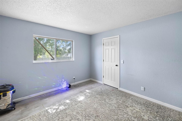 9642 Elgin Blvd, Spring Hill, FL 34606 - empty room with a textured ceiling, wood finished floors, and baseboards
