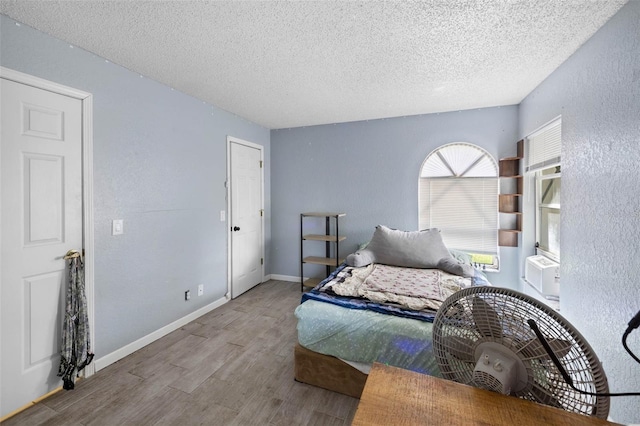 9642 Elgin Blvd, Spring Hill, FL 34606 - bedroom with a textured ceiling, wood finished floors, baseboards, and a textured wall