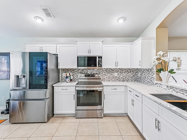 1338 Winding Willow Dr, Trinity, FL 34655 - kitchen with appliances with stainless steel finishes, white cabinets, light countertops, and backsplash
