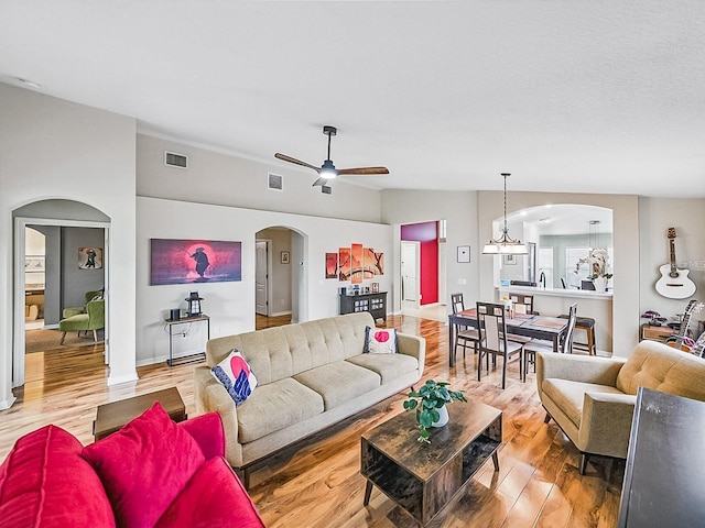 1338 Winding Willow Dr, Trinity, FL 34655 - living room with arched walkways, wood finished floors, and a ceiling fan