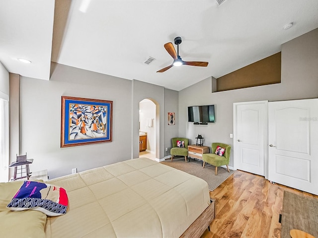 1338 Winding Willow Dr, Trinity, FL 34655 - bedroom with arched walkways, light wood-type flooring, lofted ceiling, connected bathroom, and ceiling fan