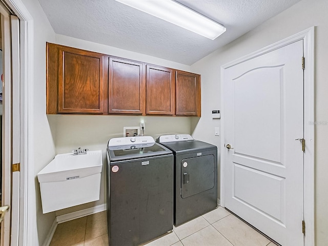 1338 Winding Willow Dr, Trinity, FL 34655 - laundry room with washing machine and clothes dryer, cabinet space, light tile patterned floors, and a textured ceiling