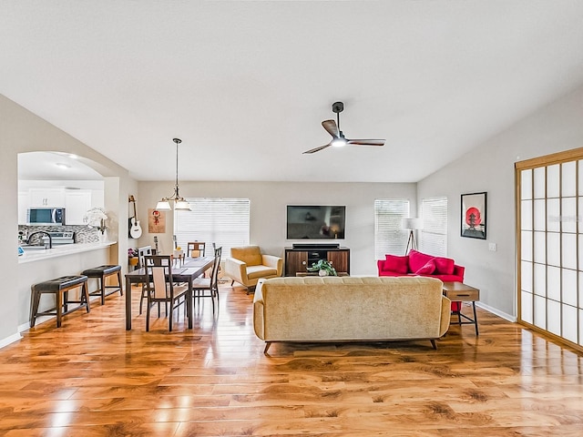 1338 Winding Willow Dr, Trinity, FL 34655 - living area with ceiling fan, light wood-style floors, vaulted ceiling, and arched walkways