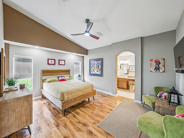 1338 Winding Willow Dr, Trinity, FL 34655 - bedroom with arched walkways, light wood finished floors, vaulted ceiling, connected bathroom, and a ceiling fan