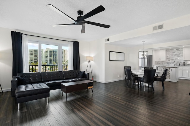1501 Gulf Blvd Unit 201, Clearwater Beach, FL 33767 - living area with a ceiling fan, dark wood-style flooring, a textured ceiling, and a chandelier